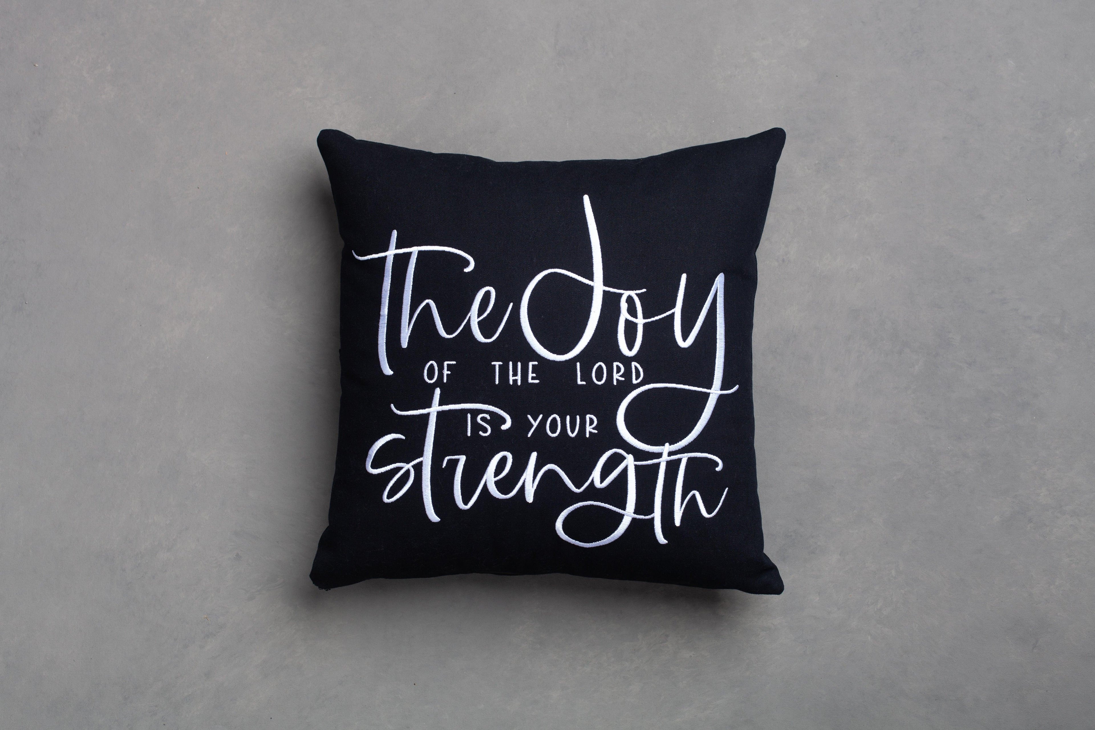 Black Joy & Strength embroidered throw pillow cover on grey background – hand-stitched Nehemiah 8:10 'joy of the Lord is your strength' in premium cotton