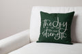 Green Joy & Strength embroidered throw pillow on white sofa – vibrant Nehemiah 8:10 verse uplifts contemporary faith-inspired space