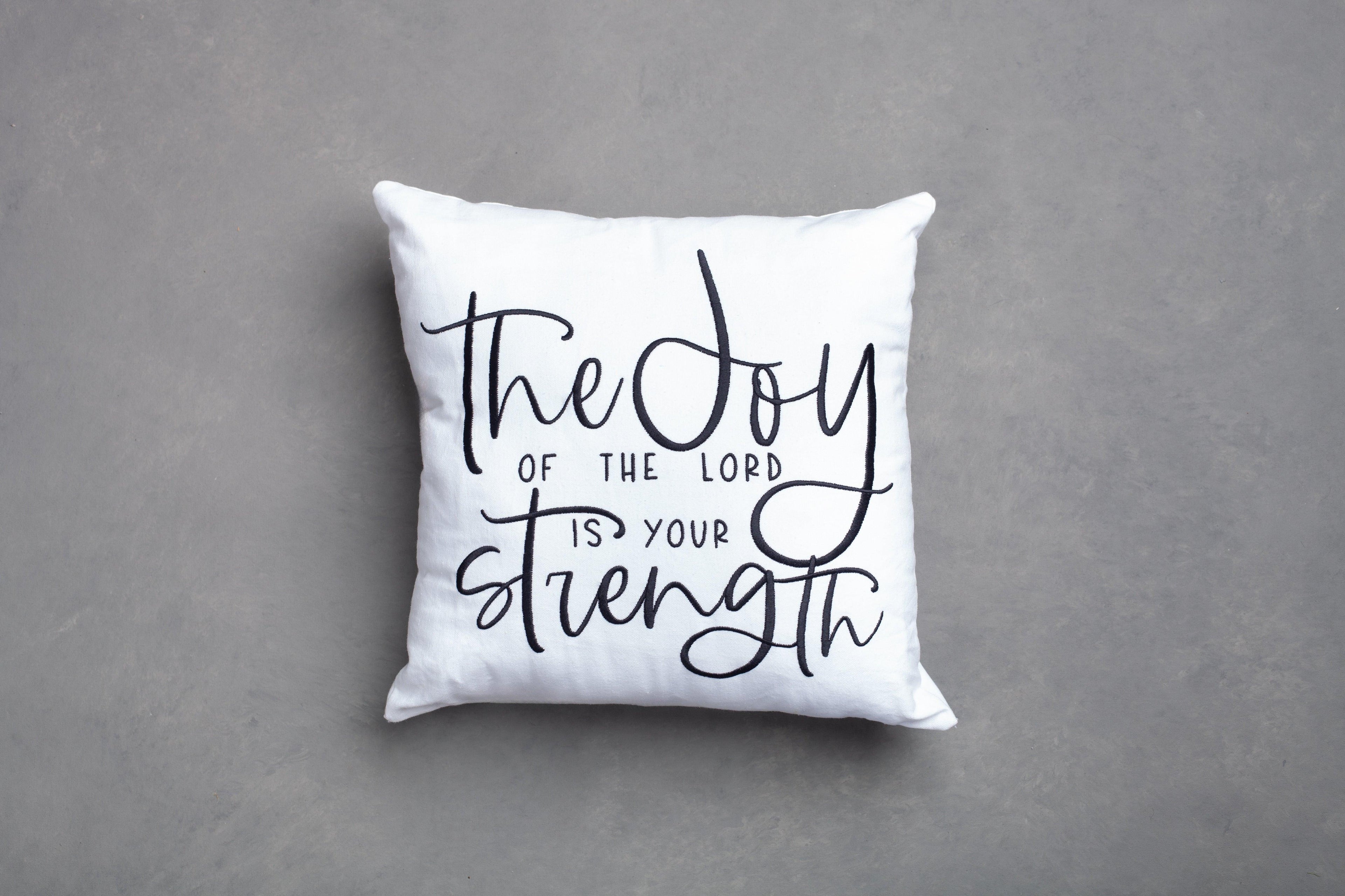 White Joy & Strength embroidered pillow cover – clean hand-embroidered Nehemiah 8:10 design on grey background, removable faith strength throw